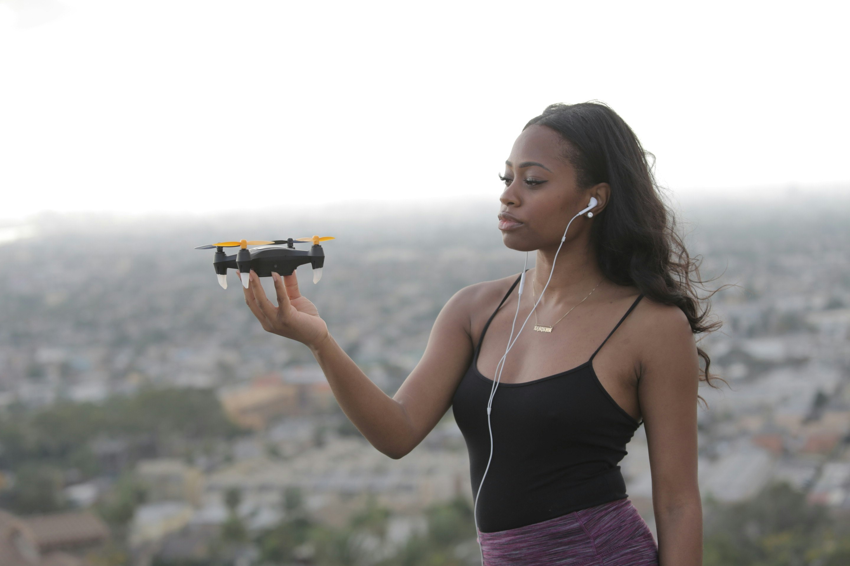 woman in purple tank top holding black camera during daytime